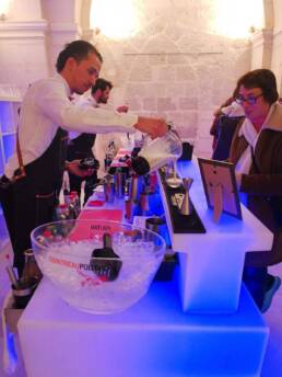 Barman au bar lumineux préparant des cocktails - Esprit Cocktail